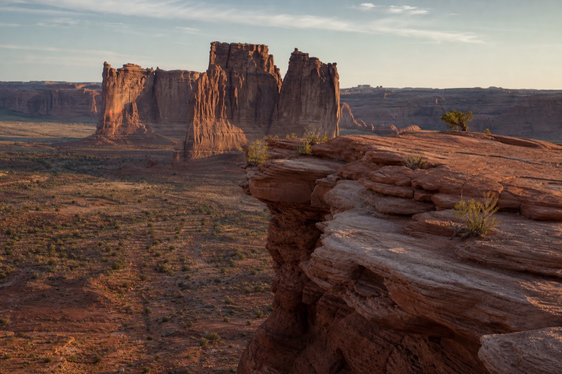 The John Ford Point promontory jutting over the valley floor with red sandstone spires beyond in late afternoon light