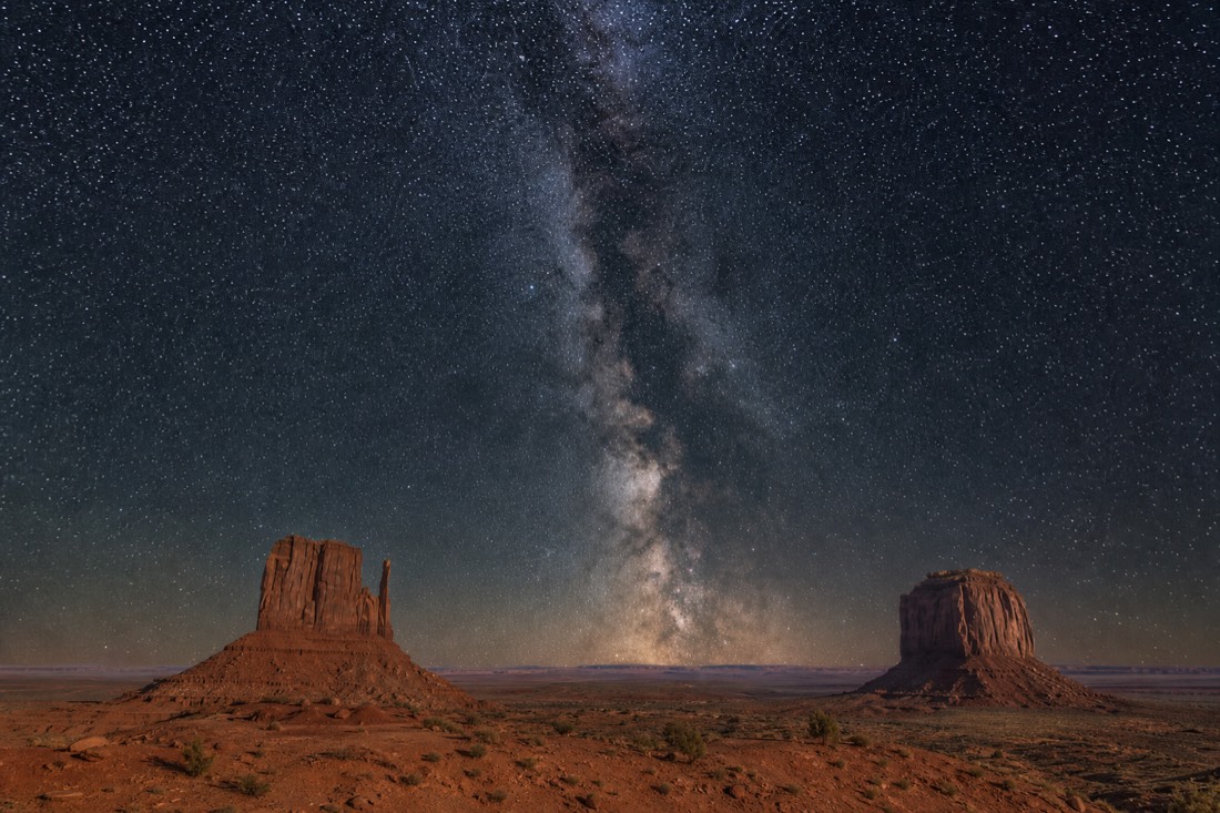 The Milky Way core rising as a bright band above the twin Mitten Buttes on a clear new-moon spring night
