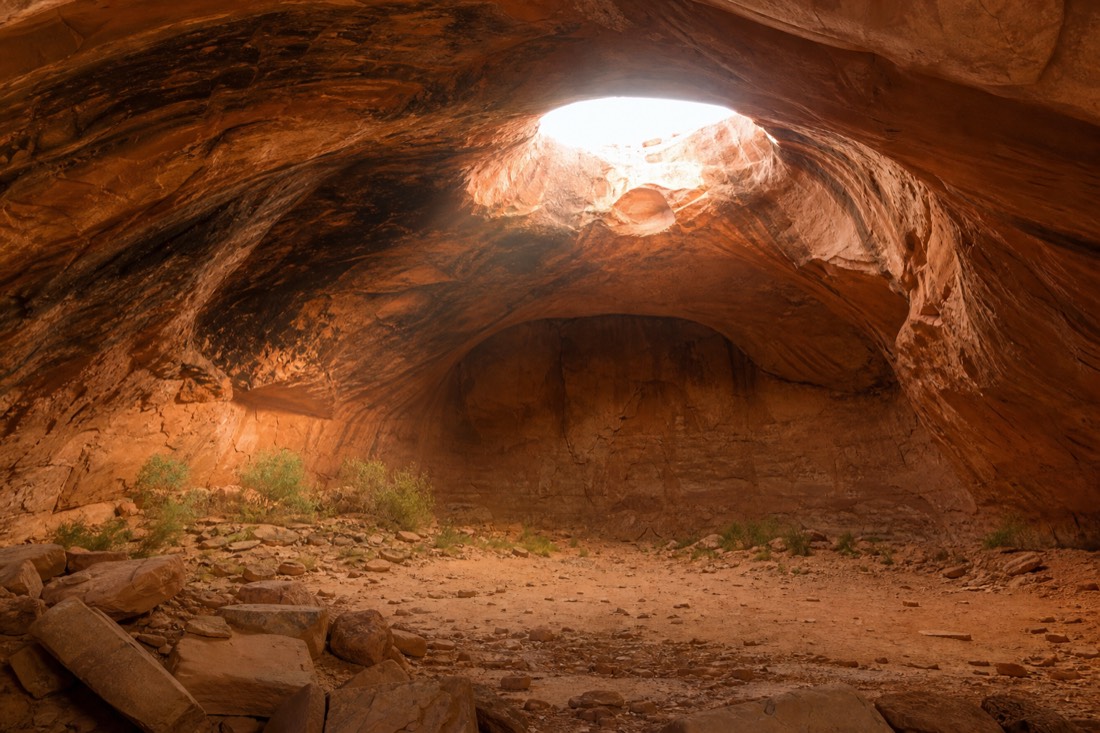 The Big Hogan, a vast domed sandstone chamber in the Monument Valley backcountry with light filtering from above