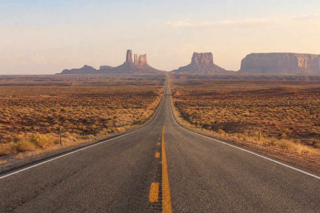 US-163 highway running dead straight toward the Monument Valley buttes at Forrest Gump Point